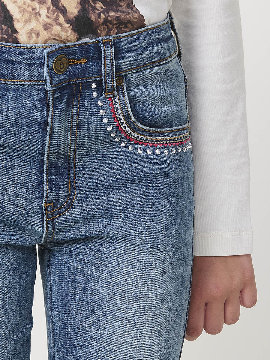 Pantalón de niña en denim elástico azul medio, pierna acampanada con cortes laterales, cinco bolsillos y cintura regulable. - Image 9