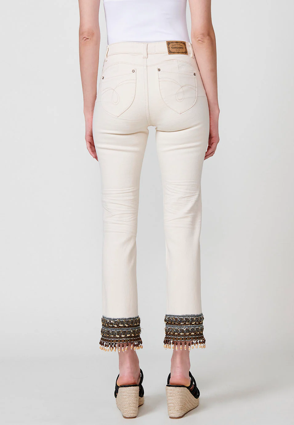 Pantalón jeans elástico cropped push up slim de tiro medio y cinco bolsillos con cierre con cremallera y botón metálico y detalle bordado con lentejuelas y flecos con abalorios y bolas de madera en el bajo para mujer - Image 5
